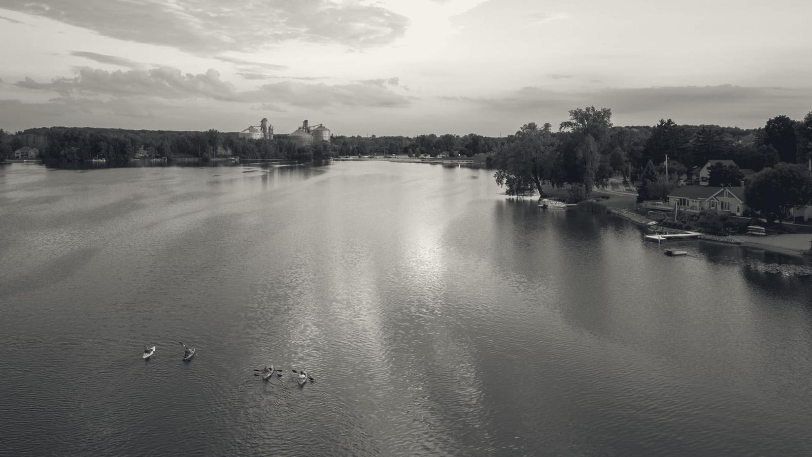 Aerial photograph of Random Lake, Wisconsin, with kayaks on the water, shoreline homes and the grain elevators beyond: Couillard Electric’s home base in Sheboygan County.