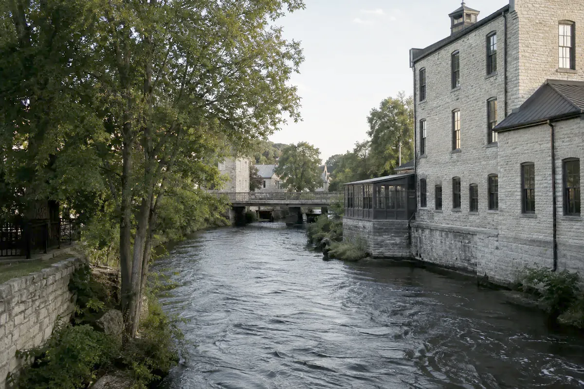 Illustration of Cedarburg: a stone mill beside a tree-lined creek.